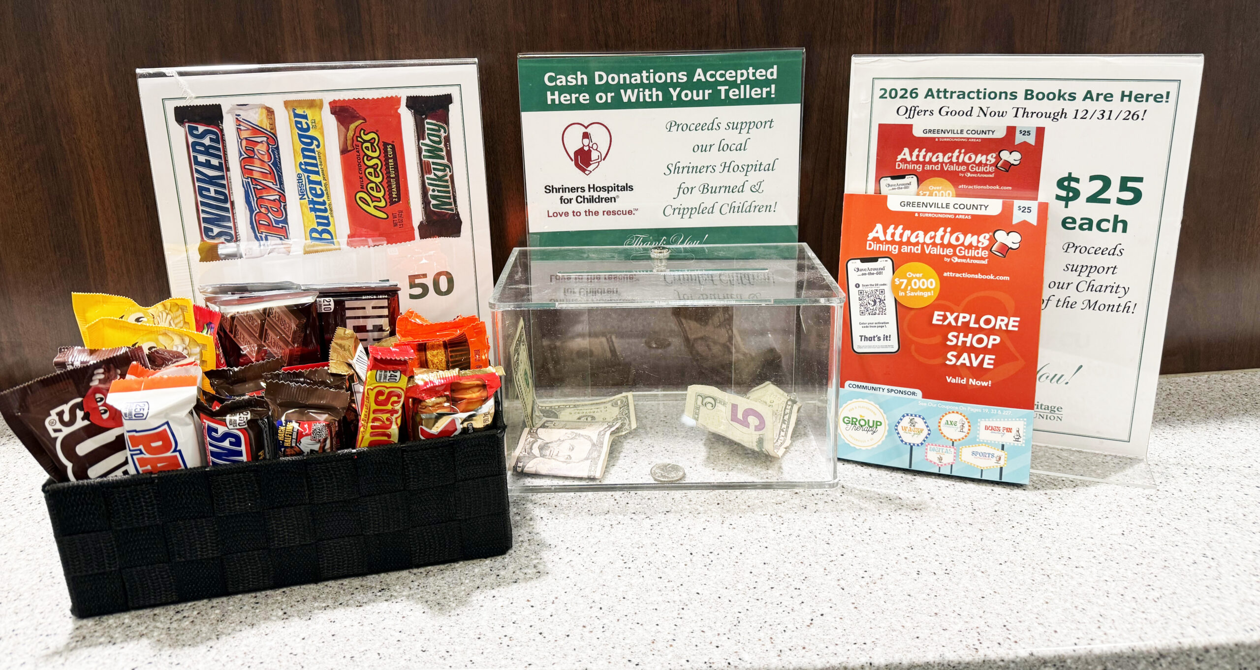 Candy, money, and Attractions Books displayed in Greenville Heritage Federal Credit Union Branch for month of February