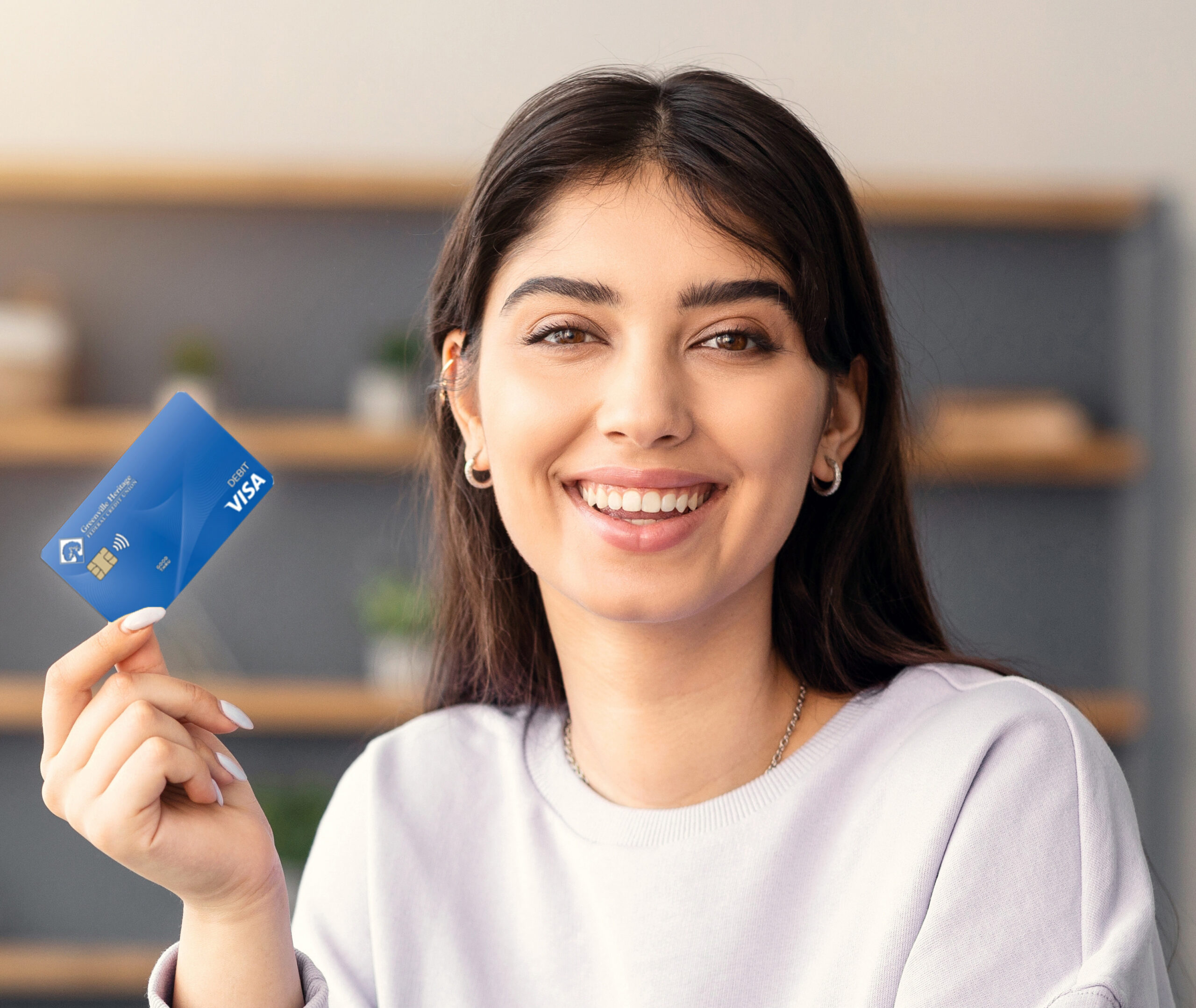 Making Financial Transaction. Portrait of smiling young lady holding and showing golden credit card, sitting at desk with laptop computer at home, looking at camera. Online Money Transfer Concept