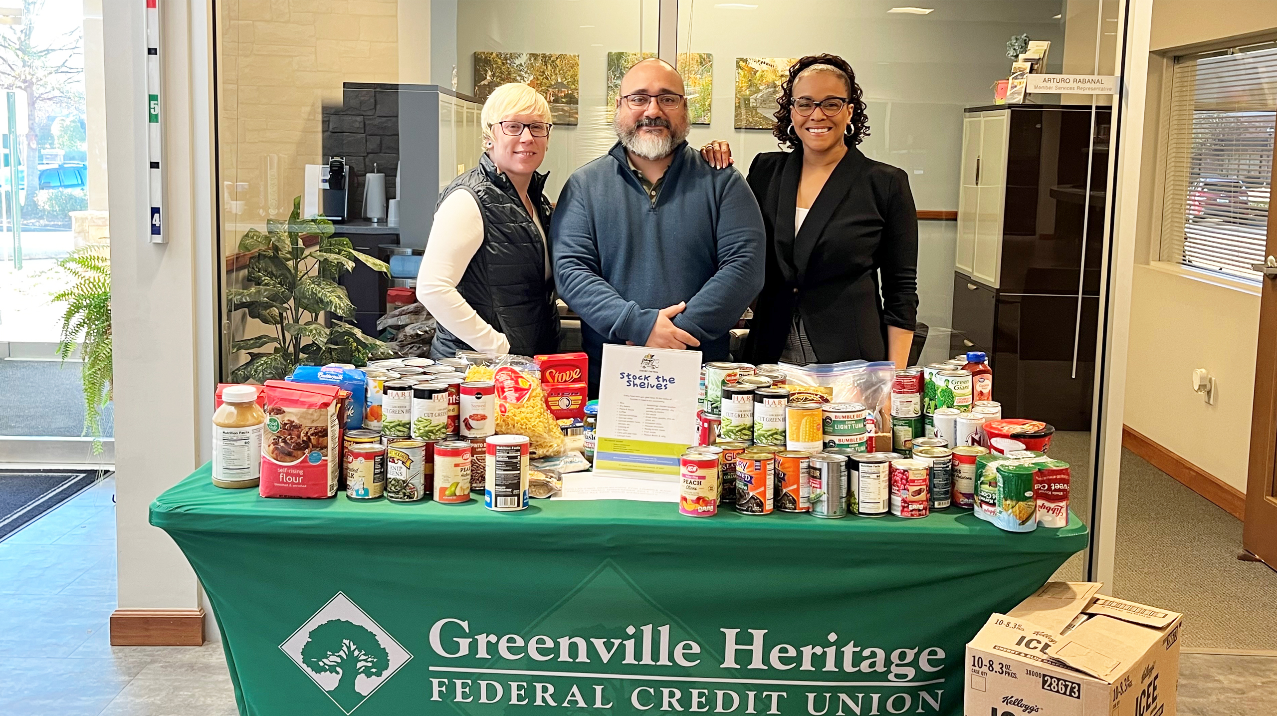GHFCU employees collecting canned food for the Loaves and Fishes Stock the Shelves campaign.