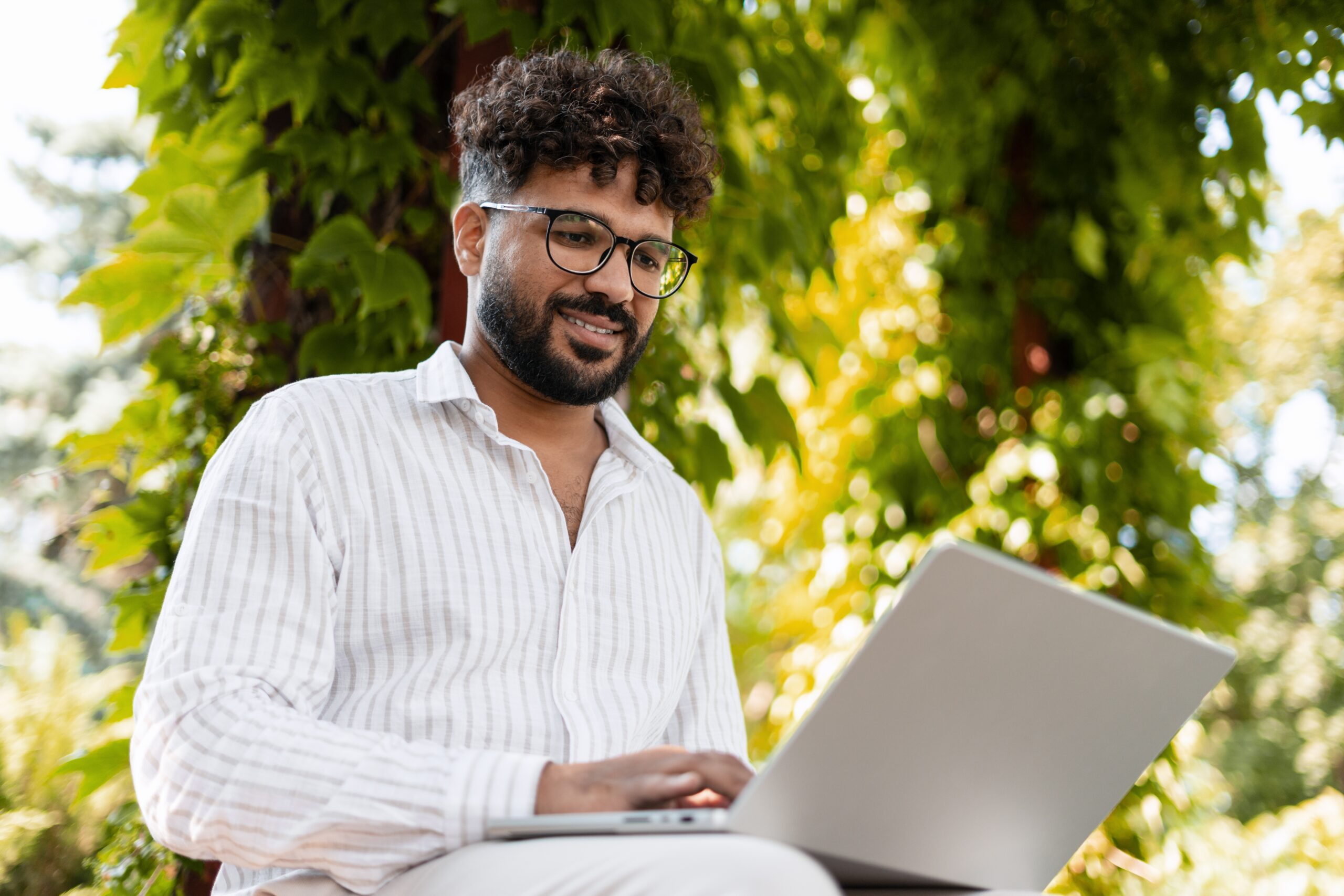 Young,Businessman,Working,Remotely,Outdoors,In,A,Park,,Using,A